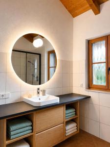 a bathroom with a sink and a mirror at NaturZeit Melleck in Schneizlreuth +26 photos