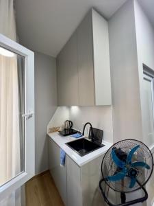 a small white kitchen with a sink and a chair at Maya Seaside Ureki in Ureki