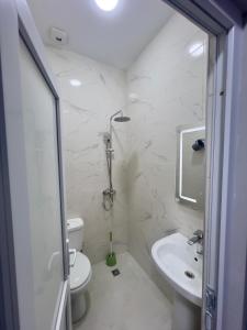 a white bathroom with a toilet and a sink at Maya Seaside Ureki in Ureki