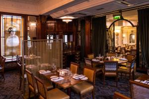 a restaurant with tables and chairs and a woman in a window at The Royal Toby Hotel in Rochdale