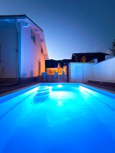 a swimming pool with blue lights in a backyard at Holiday house Leona in Otočac