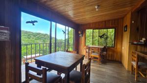 a dining room with a table and a large window at Monteverde Monkey Hostel in Monteverde Costa Rica +48 photos