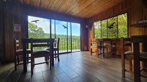 a dining room with birds flying over a balcony at Monteverde Monkey Hostel in Monteverde Costa Rica