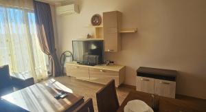 a living room with a flat screen tv and a table at Sun Sea App in Shkorpilovtsi +46 photos
