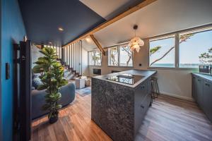 a kitchen with a large island in a room with windows at appartement Picasso - une évasion face à l'océan in Santec
