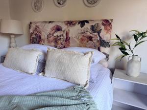 a bedroom with a bed with pillows and a floral headboard at Lielies Guesthouse in Parys +49 photos