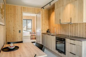 a kitchen with wooden walls and a wooden table and a kitchen with a bed at Filefjellstuene Hotel in Tyinkrysset +24 photos