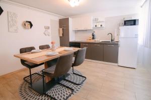 a kitchen and dining room with a table and chairs at Soba i Apartman Đula in Ogulin