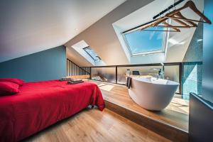 a bedroom with a large bed and a bath tub at appartement Picasso - une évasion face à l'océan in Santec