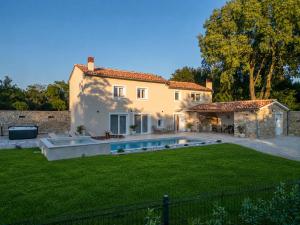 a house with a swimming pool in front of a yard at Villa de Pucci in Žminj