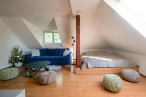 a attic bedroom with a bed and a blue couch at Michell Apartman Martin in Martin