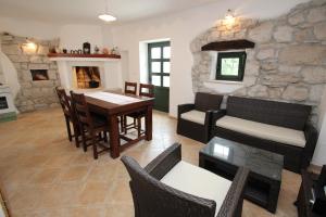sala de estar con mesa y pared de piedra en Holiday Home Vinkovic, en Poreč