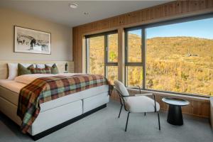 a bedroom with a bed and a large window at Filefjellstuene Hotel in Tyinkrysset