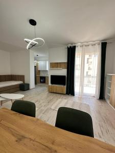 a living room with a table and chairs and a living room at A&H Apartment 2 in Shëngjin