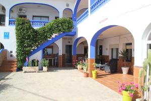 a blue and white building with blue arches and plants at Apartamentos Miramar in Bolonia