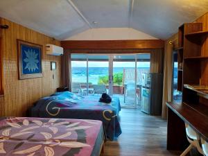 a bedroom with two beds and a view of the ocean at Vahaui Paradis in Avatoru