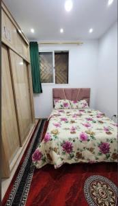 a bedroom with a large bed with flowers on it at Résidence Erahha in Agadir