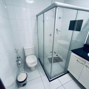 a bathroom with a toilet and a glass shower at Pousada Dipajuçara in Maceió
