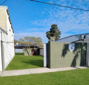 a house with a green yard with a wall at Alojamiento Ruta 51 in La Banda +1 photo