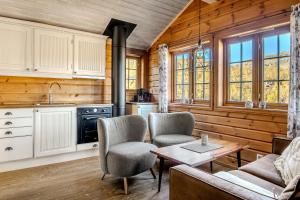 a kitchen and living room with a table and chairs at Filefjellstuene hytter og leiligheter in Tyinkrysset