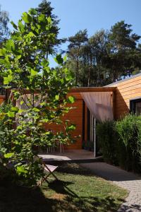 a wooden house with a tree in front of it at Seaside Harmony in Pogorzelica