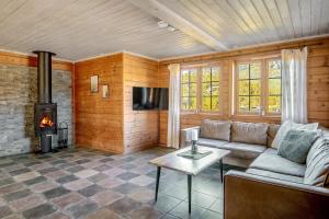 a living room with a couch and a fireplace at Filefjellstuene hytter og leiligheter in Tyinkrysset