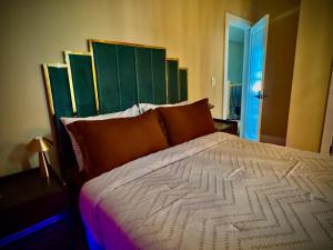 a bedroom with a large bed with a green headboard at La Suite de Antonio Shared Property PRIVATE stay NYC 18mins in North Bergen