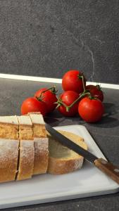 a sandwich on a plate with a knife and tomatoes at GreveLuxious in Grevena +3 photos