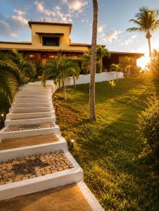 a pathway leading to a house with a palm tree at Pousada Villa Jodie in Fortim +7 photos