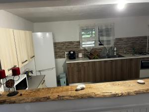 a kitchen with a wooden counter top in a room at Aux bambous in Rivière-Salée