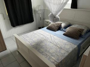 a bedroom with a bed with a canopy and pillows at Aux bambous in Rivière-Salée