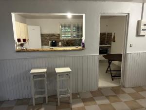 a kitchen with a counter and two stools in a room at Aux bambous in Rivière-Salée