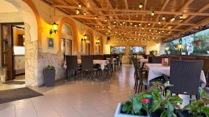 a dining room with tables and chairs in a restaurant at Patyi Étterem és Hotel in Bögöte