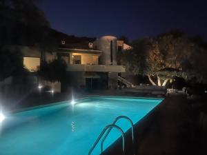 a swimming pool in front of a house at night at A Villa Rosa in Santa-Maria-di-Lota