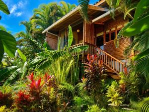 a wooden house surrounded by plants and trees at Horizon Hotel & Yoga Center in Santa Teresa Beach
