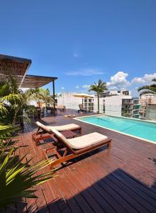 a swimming pool with chaise lounges next to a swimming pool at Ah Xok suites 5a Avenida in Playa del Carmen