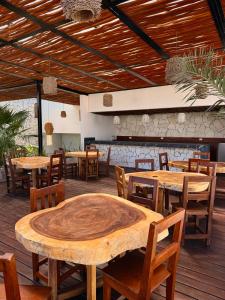 a restaurant with wooden tables and wooden chairs at Ah Xok suites 5a Avenida in Playa del Carmen