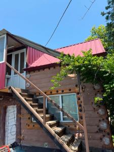 a house with stairs and a red roof at Rezo's Ranch Cottage in Samtredia +4 photos