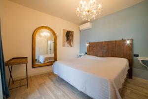 a bedroom with a large bed and a mirror at Robur Gardae Panoramic Suite in Torri del Benaco