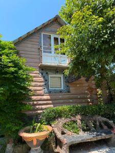 a house with a window and a bench in front of it at Rezo's Ranch Cottage in Samtredia