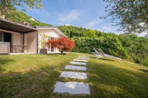 a garden with stepping stones in the grass at Robur Gardae Panoramic Suite in Torri del Benaco