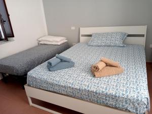 two beds in a bedroom with towels on them at Pietramarina162 in Camerota