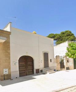 a white building with a brown door and a tree at Casa Salento Diso in Diso