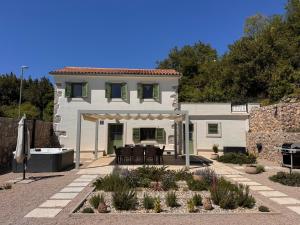 a white house with a patio with a table and chairs at Hidden House Porta in Krk