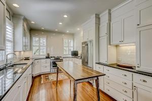a large kitchen with white cabinets and a wooden table at Luna Sea in Edisto Beach