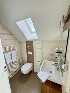 a bathroom with a sink and a toilet and a skylight at Hotel Markgräfler Hof in Badenweiler +39 photos