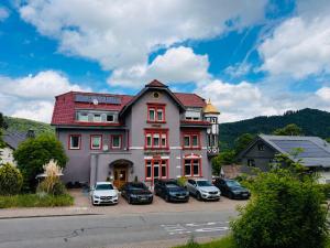 a large building with cars parked in front of it at Hotel Markgräfler Hof in Badenweiler