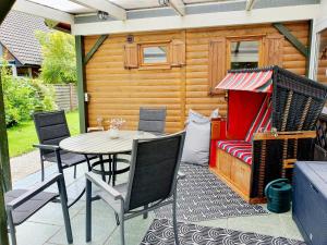 a patio with a table and chairs and a couch at Zeit für uns in Cuxhaven