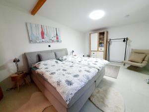 a bedroom with a bed and a chair in it at Zeit für uns in Cuxhaven