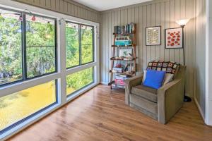 a living room with a chair and large windows at The Pirate Den in Edisto Beach